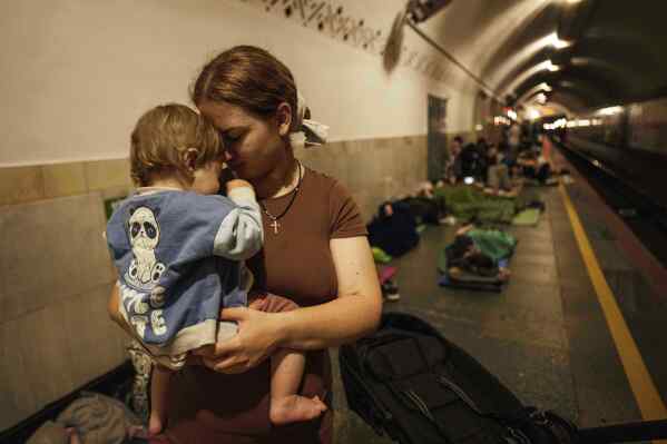Oleksandra Umanets, 23, calms her 10-month-old son as they take cover on the platform of a metro station during a Russian attack on Kyiv, Ukraine, on Thursday, July 10, 2025. (AP Photo/Evgeniy Maloletka)