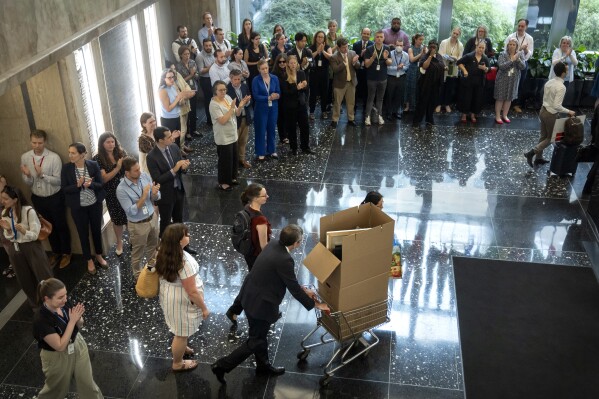 State Department employees applaud as their colleagues walk through the lobby of the State Department headquarters in the Harry S Truman Building, Friday, July 11, 2025, in Washington. (AP Photo/Mark Schiefelbein).