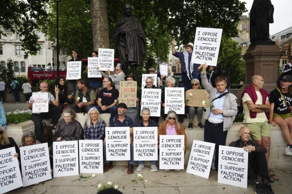 People take part in a protest in support of 'Palestine Action', organised by the Defend Our Juries group, in front of the Mahatma Gandhi statue in Parliament Square in London, England, Saturday, July 5, 2025. (Jeff Moore/PA via AP)