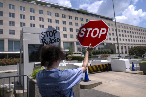 Former Foreign Service employee Anne Bodine of Arlington, Va., demonstrates against potential layoffs at the State Department, Friday, July 11, 2025, in Washington. (AP Photo/Mark Schiefelbein).