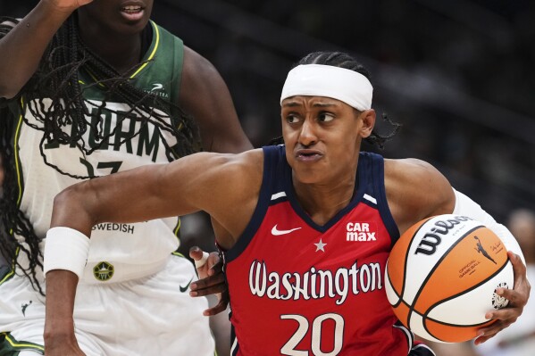Washington Mystics guard Brittney Sykes (20) drives against Seattle Storm forward Ezi Magbegor, left, during the second half of a WNBA basketball game Sunday, July 13, 2025, in Seattle. (AP Photo/Lindsey Wasson)