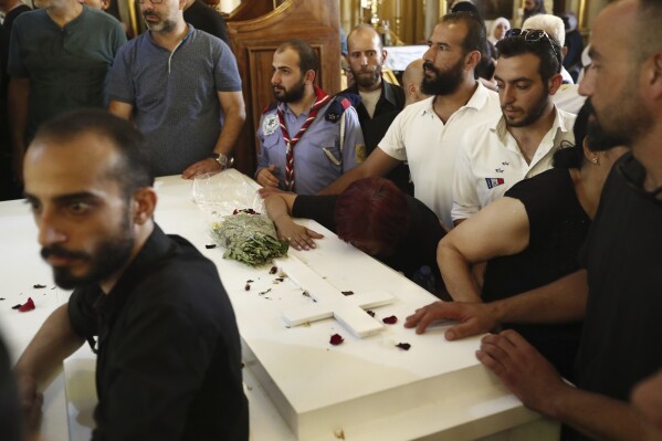 Mourners gather around the coffin of a victim of Sunday's suicide bombing at Mar Elias Greek Orthodox Church, during a funeral service held at al-Saleeb Church in the al-Qasaa neighborhood of Damascus, Syria, Tuesday, June 24, 2025. (AP Photo/Omar Sanadiki)