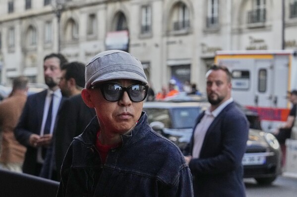 Designer Nigo poses for photographers following the men's Kenzo Spring-Summer 2026 collection, that was presented in Paris, Friday, June 27, 2025. (AP Photo/Michel Euler)