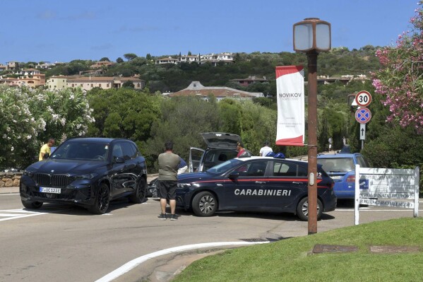 The covered body of Gaia Costa, 24, bottom center, on the site where she was struck by a vehicle in Porto Cervo, Sardinia, Italy, Tuesday, July 8, 2025. (Vanna Sanna, La Nuova Sardegna via AP)