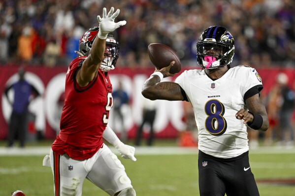 Baltimore Ravens quarterback Lamar Jackson (8) is pressured by Tampa Bay Buccaneers linebacker Joe Tryon-Shoyinka (9) during the first half of an NFL football game, Monday, Oct. 21, 2024, in Tampa, Fla. (AP Photo/Jason Behnken)