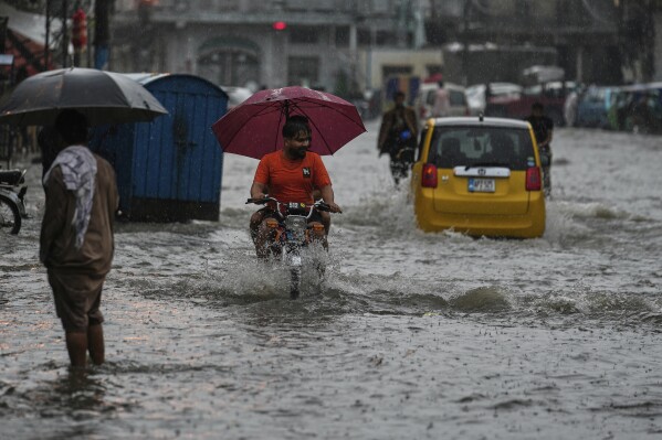 Motorists drive through a flooded road during monsoon rainfall, in Rawalpindi, Pakistan, Thursday, July 17, 2025. (AP Photo/Anjum Naveed)