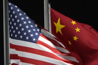 The American and Chinese flags wave, Feb. 2, 2022, in Zhangjiakou, China. (AP Photo/Kiichiro Sato, File)