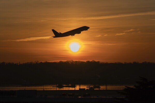 An airplane lifts off from Ronald Reagan Washington National Airport as the sun rises Monday, Feb. 3, 2025, in Arlington, Va. (AP Photo/Jose Luis Magana)