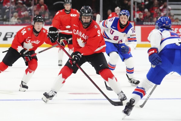 Canada's Gavin McKenna (9) skates with the puck as United States' Drew Fortescue (5) defends during the second period of an IIHF World Junior Hockey Championship tournament game in Ottawa, Ontario, Dec. 31, 2024. (Sean Kilpatrick/The Canadian Press via AP, File)