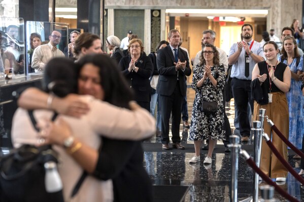 State Department employees applaud as their colleagues walk through the lobby of the State Department headquarters in the Harry S Truman Building, Friday, July 11, 2025, in Washington. (AP Photo/Mark Schiefelbein)