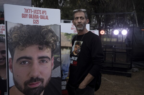 FILE - Ilan Dalal, father of Guy Gilboa-Dalal, who was kidnapped on Oct. 7 in a cross-border attack by Hamas at the Nova music festival, stands next to a photo of his son during a press conference at the site in Re'im, southern Israel, Friday, Jan. 5, 2024. (AP Photo/Maya Alleruzzo)
