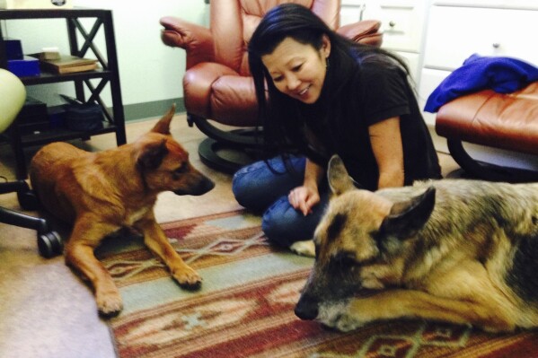This undated photo provided by Sherry Gaber shows Betsy Arakawa with her dogs Zinna, left, and Bear, in Santa Fe, N.M. (Sherry Gaber via AP)