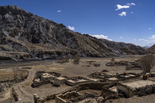 El poblado abandonado de Samjung --con cuevas antiguas en los acantilados al fondo-- puede apreciarse en la región de Mustang, el viernes 18 de abril de 2025, al oeste de Katmandú, Nepal. (AP Foto/Niranjan Shrestha)