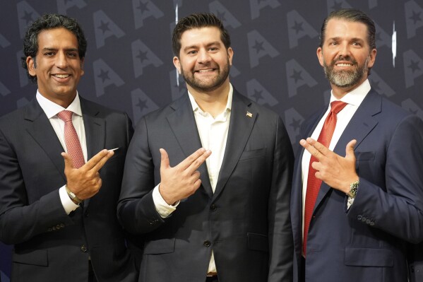 GrabAGun CEO Marc Nemati, center, board member Donald Trump, Jr., right, and financier Omeed Malik pose for a picture on the floor at the New York Stock Exchange in New York, Wednesday, July 16, 2025. (AP Photo/Seth Wenig)