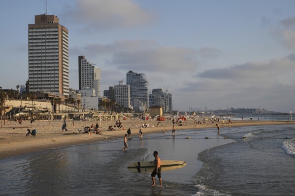 People spend the day on the Mediterranean Sea beachfront in Tel Aviv, Israel, on Saturday, June 14, 2025. (AP Photo/Ohad Zwigenberg)