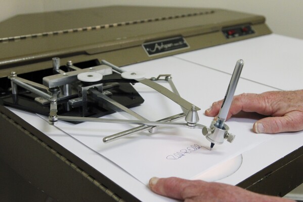 FILE - In this photo taken June 13, 2011, Bob Olding, president of Damilic Corp., the leading manufacture of automatic signing machines for replicating authentic signatures, demonstrates the features of the older model Autopen Model 80 in Rockville, Md. Autopens have been used for decades by presidents of both parties, an open secret nobody in Washington wants to talk about, including the White House. (AP Photo/Manuel Balce Ceneta)