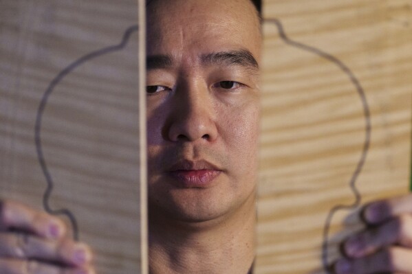 Malaysian luthier Tan Chin Sang checks the maple for a violin back plate at his workshop in the outskirt of Kuala Lumpur, Malaysia, Thursday, July 2, 2025. (AP Photo/Vincent Thian)