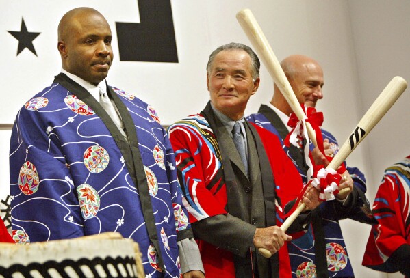 Wearing traditional Japanese "Hapi" coats San Francisco Giants star Barry Bonds, left, is watched by Japanese baseball legend Shigeo Nagashima standing near New York Mets manager Art Howe after breaking open a barrel of sake with baseball bats at a party in Tokyo in this Nov. 7, 2002.(AP Photo/David Guttenfelder, File)