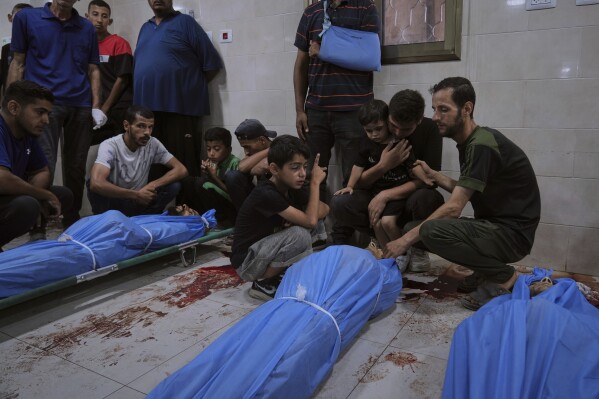 Mourners attend the funeral of victims who were killed in an Israeli bombardment of Gaza Strip, at the Al-Awda Hospital in Nuseirat, on Tuesday, July 8, 2025. (AP Photo/Abdel Kareem Hana)