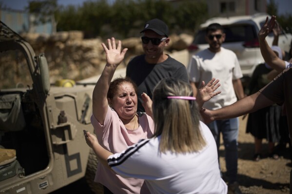 A Syrian Druze woman bids farewell to Druze relatives and friends from Israel before crossing back into Syria at the Israeli-Syrian border, in the Israeli-controlled Golan Heights town of Majdal Shams, Thursday, July 17, 2025. (AP Photo/Leo Correa)