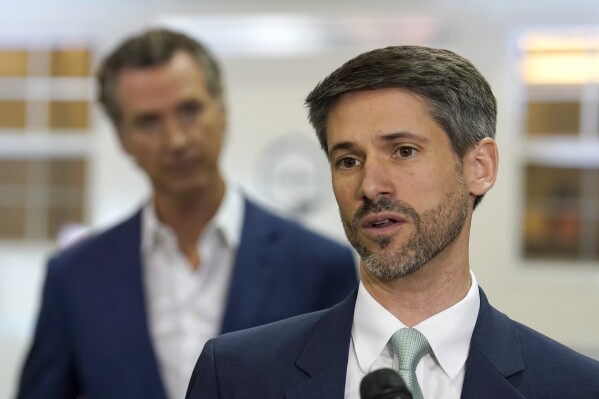 San Jose Mayor Matt Mahan, right, discusses California Gov. Gavin Newsom's, left, proposal to build 1,200 small homes across the state to reduce homelessness, during the first of a four-day tour of the state in Sacramento Calif., Thursday, March 16, 2023. (AP Photo/Rich Pedroncelli, File)
