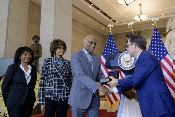 House Speaker Mike Johnson, R-La., right, presents the Congressional Gold Medal to Stanley Earley III, son of Lt. Col. Charity Adams Earley, second from right, as Judith Earley, second from left, and retired Amy Col. Edna W. Cummings, left, watch during a ceremony honoring the Six Triple Eight, on Capitol Hill, Tuesday, April 29, 2025, in Washington. (AP Photo/Rod Lamkey, Jr.)