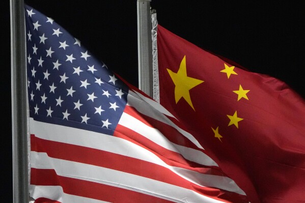 The American and Chinese flags wave, Feb. 2, 2022, in Zhangjiakou, China. (AP Photo/Kiichiro Sato, File)