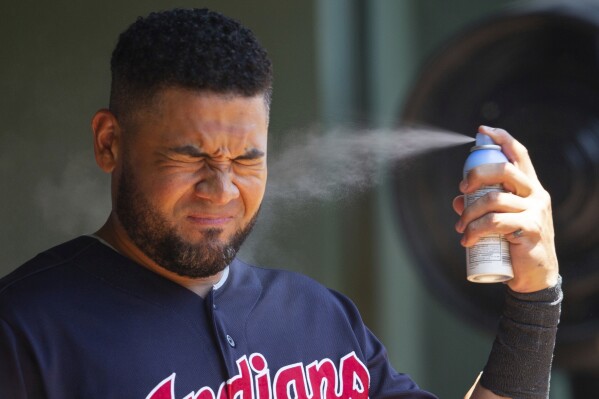 Cleveland Indians right fielder Melky Cabrera sprays sunscreen before a baseball game against the Texas Rangers, Sunday, July 22, 2018, in Arlington, Texas. (AP Photo/Sam Hodde, File)