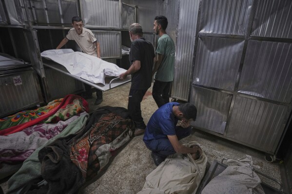 The bodies of Palestinians killed while on their way to an aid distribution center are prepared for burial at the morgue of Shifa Hospital in Gaza City, Thursday, July 3, 2025. (AP Photo/Jehad Alshrafi)