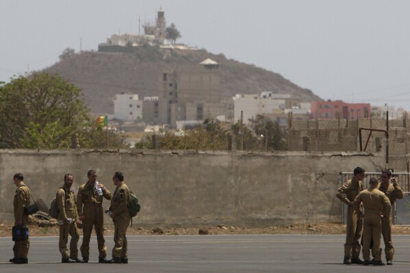 Members of a French military flight crew talk on the tarmac at France's military air base in Dakar, Senegal, Tuesday, June 2, 2009. (AP Photo/Rebecca Blackwell, File)