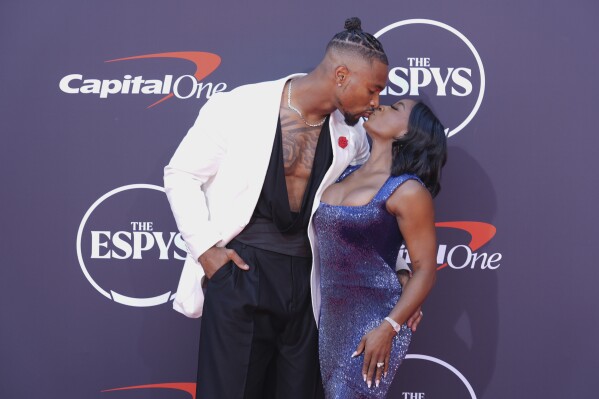 Jonathan Owens, left, kisses Simone Biles as they arrive at the ESPY Awards at the Dolby Theatre in Los Angeles, Wednesday, July 16, 2025. (AP Photo/Chris Pizzello)