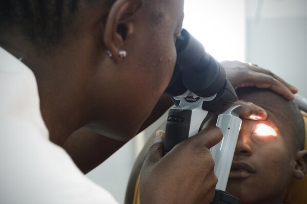 Dr. Claudette Yaméogo, Burkina Faso's only ophthalmologist specializing in treating children, checks Isaka Diallo who has lost vision in his left eye at the Sanou Sourou University Hospital in the city of Bobo-Dioulasso, Burkina Faso, Thursday, June 5, 2025. (AP Photo/Elia Borras)