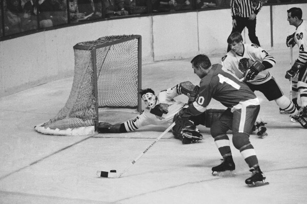 Chicago Blackhawk goalie Tony Esposito stretches to block Detroit Red Wing Captain Alex Delvecchio shot as Keith Magnuson moves in on defense, during the third period of a Stanley Cup hockey playoff game in Detroit, April 13, 1970. (AP Photo, File)