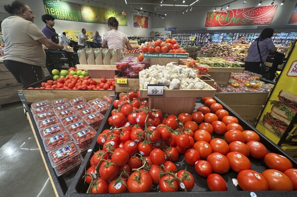 Tomatoes are displayed as customers shop at a grocery store in Glenview, Ill., Tuesday, July 15, 2025. (AP Photo/Nam Y. Huh)