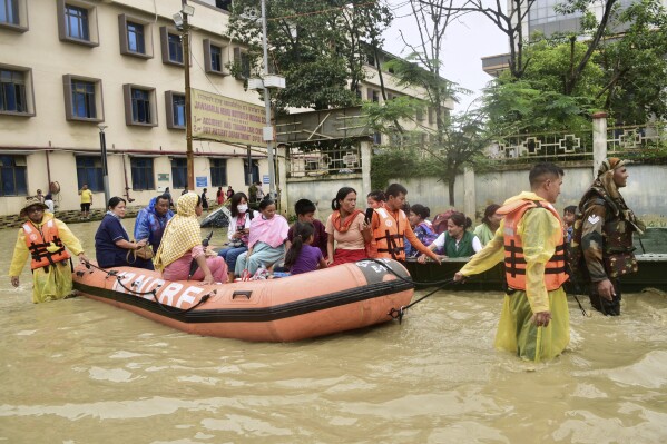 Army soldiers and rescuers evacuate patients and medical staff from a flooded hospital following landslides and flash flooding amid monsoon season in Imphal, India, June 1, 2025. (AP Photo/Donald Sairem, File)