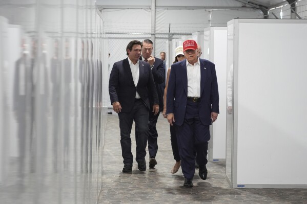 President Donald Trump, Gov. Ron DeSantis, R-Fla., Homeland Security Secretary Kristi Noem and others, tour "Alligator Alcatraz," a new migrant detention facility at Dade-Collier Training and Transition facility, Tuesday, July 1, 2025, in Ochopee, Fla. (AP Photo/Evan Vucci)