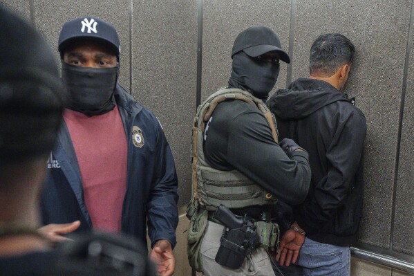Immigration and Customs Enforcement agents escort a detained immigrant into an elevator after he exited an immigration courtroom, Tuesday, June 17, 2025, in New York. (AP Photo/Olga Fedorova, file)