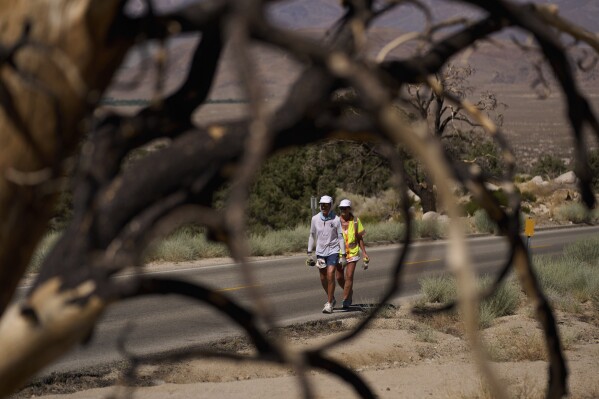 Danny Westergaard, left, competes during the Badwater 135 Ultramarathon beside Jennifer Drain, his cousin and crew lead, Wednesday, July 9, 2025, near Lone Pine, Calif. (AP Photo/John Locher)