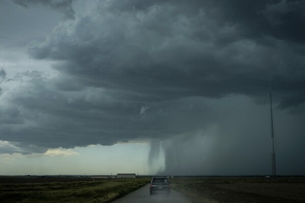 The Project ICECHIP command vehicle drives toward an approaching rainstorm with a rain shaft during an operation Tuesday, June 3, 2025, near Tipton, Okla. (AP Photo/Carolyn Kaster)