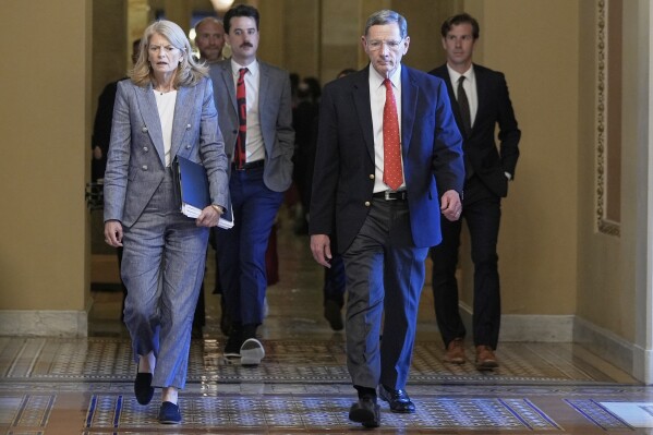Sen. Lisa Murkowski, R-Alaska, left, and Sen. John Barrasso, R-Wyo., right, walk at the Capitol, Tuesday, July 1, 2025, in Washington. (AP Photo/Mariam Zuhaib)