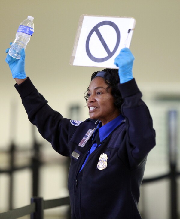 A TSA employee advises travelers that liquids are not allowed through the gate at at the Los Angeles International Airport, Oct. 10, 2012. (AP Photo/Damian Dovarganes, File)