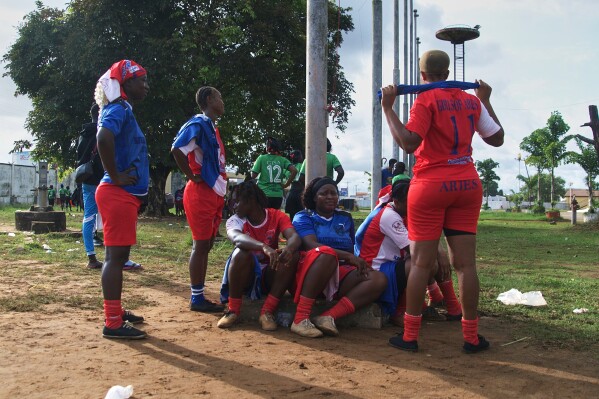 Women on the Girls of Aries kickball team, part of Liberia's professional kickball league, talk together before a match at the Samuel Kanyon Doe Stadium in Monrovia, Liberia, June 14, 2025. (AP Photo/Annie Risemberg)