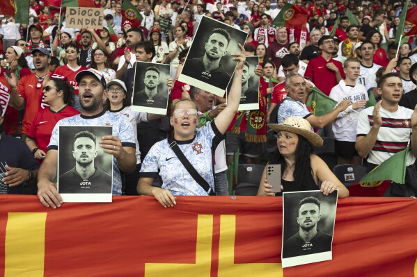 Fans hold pictures of Portuguese soccer player Diogo Jota who died in a car accident in Spain, prior to the Euro 2025, group B, soccer match between Spain and Portugal at Stadion Wankdorf in Bern, Switzerland, Thursday, July 3, 2025. (Peter Klaunzer/Keystone via AP)