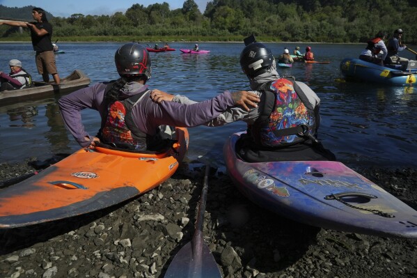 Kayakers pause before paddling the last couple of miles of the Klamath River to reach the Pacific Ocean on Friday, July 11, 2025, in Klamath, Calif. (AP Photo/Brittany Peterson)