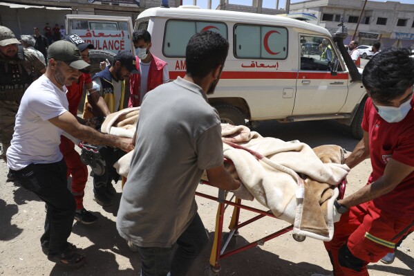 Red Crescent volunteers carry a government soldier injured in Sweida city during clashes between the government forces and Druze militias at a clinic in Busra al-Harir village, southern Syria, Tuesday, July 15, 2025. (AP Photo/Omar Albam)