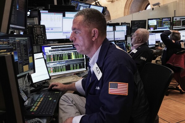 Trader Justin Flinn, left, works on the floor of the New York Stock Exchange, Friday, June 27, 2025. (AP Photo/Richard Drew)