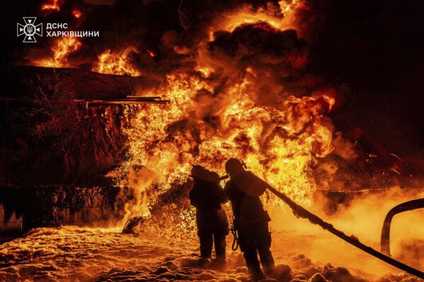 In this photo provided by the Ukrainian Emergency Service, emergency services personnel work to extinguish a fire following a Russian attack in Kharkiv region, Ukraine, Saturday, July 5, 2025. (Ukrainian Emergency Service via AP)