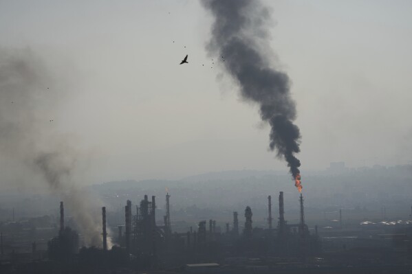 Smoke billows after an Iranian missile struck an oil refinery in Haifa, northern Israel, early Monday, June 16, 2025. (AP Photo/Ariel Schalit)