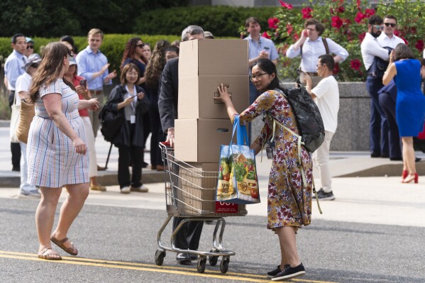 State Department employees carry boxes on a cart out of the Harry S. Truman Building, the headquarters of the State Department, in Washington, Friday, July 11, 2025. (AP Photo/Manuel Balce Ceneta)