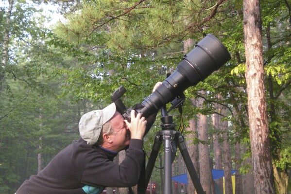 This May 2015, image provided by Doug Tallamy shows the University of Delaware entomologist and father of the modern native plants movement taking photos of warblers in Oxford, Pa. (Cindy Tallamy via AP)